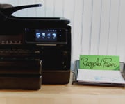 HP Officejet printer with recycled paper next to it