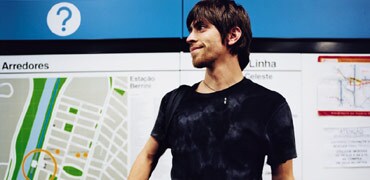 A smiling man standing in front of a large map