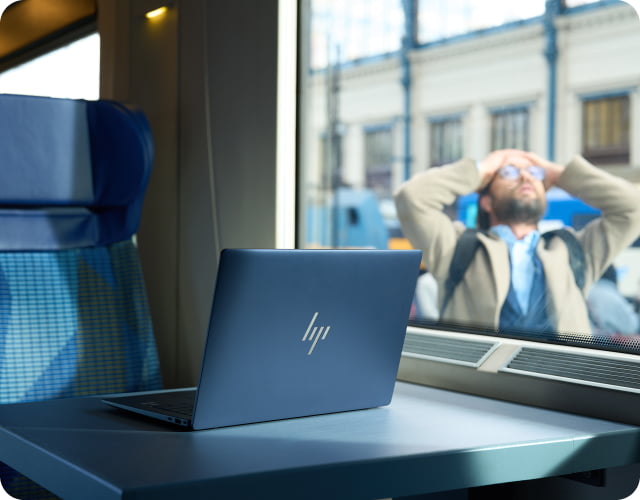 A man outside the window of a commuter train has left his laptop on the train.