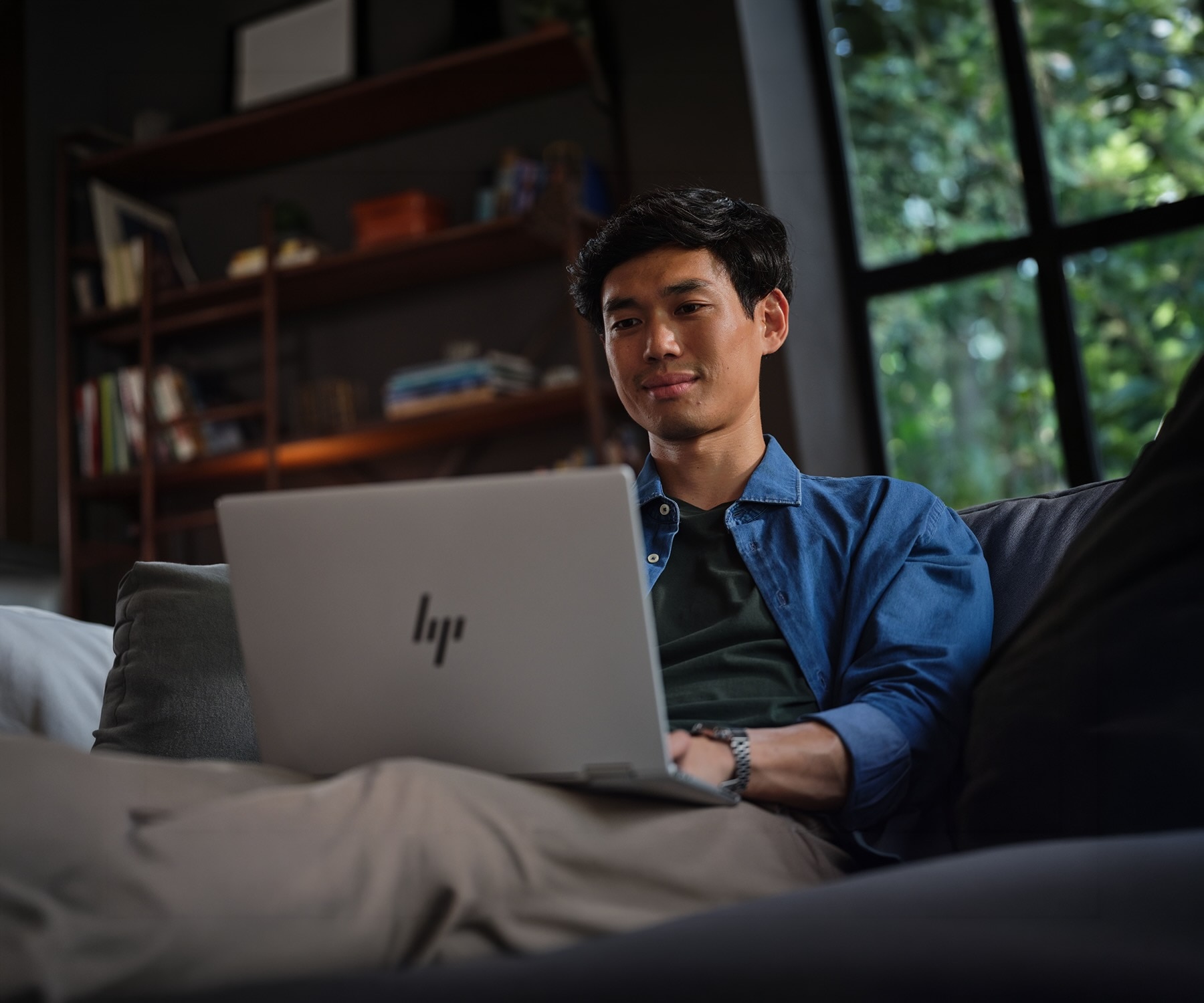 Person using HP laptop on a couch at home