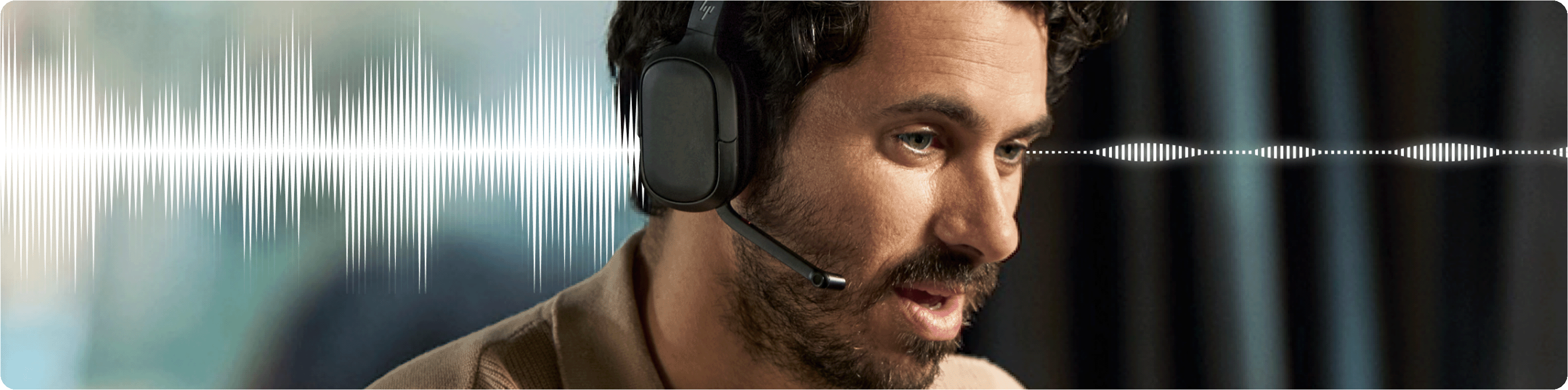 A man on a call wearing HP Poly Focus headphones with a noise-cancelling microphone for clear conversations.