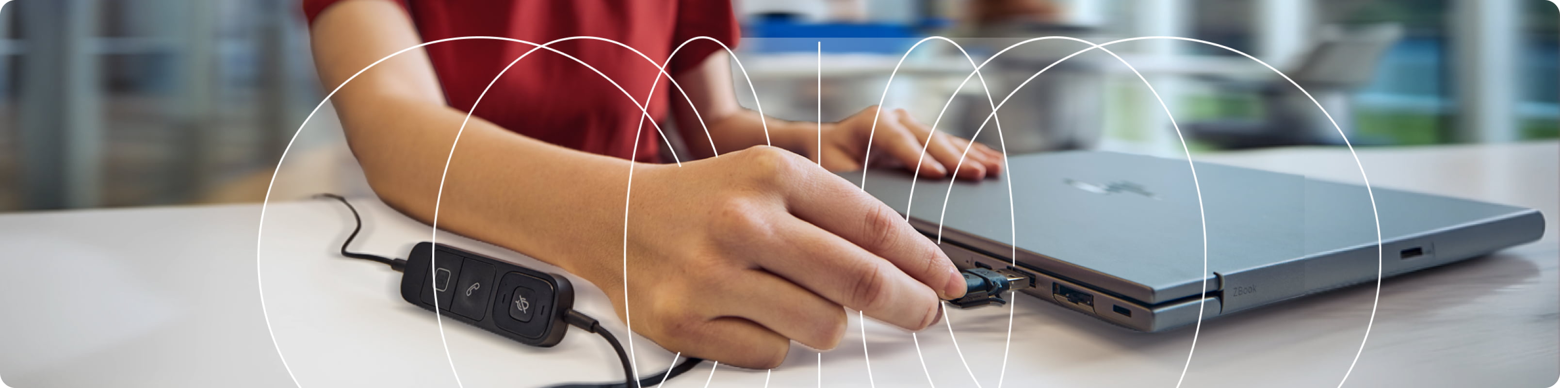 A woman connecting HP Poly Focus headphones to a laptop, highlighting easy device compatibility and reliable connectivity.