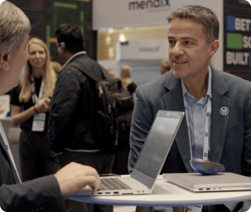 Deux professionnels sur le stand HP du Gartner Symposium, utilisant des PC portables HP