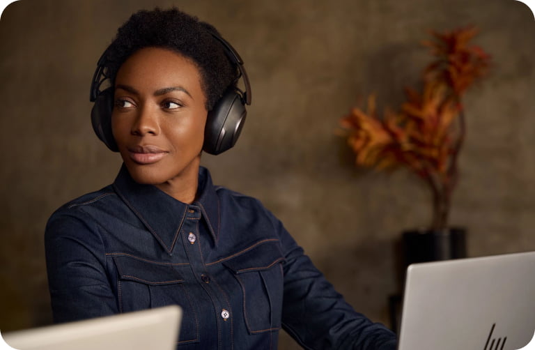 Femme portant un casque HP Poly sur un ordinateur portable et regardant vers la gauche.