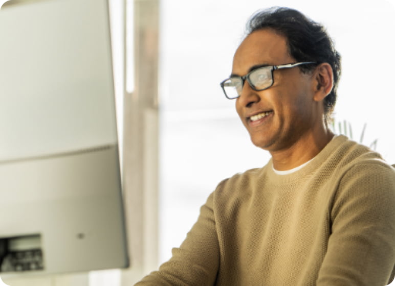 Un homme portant des lunettes et souriant.