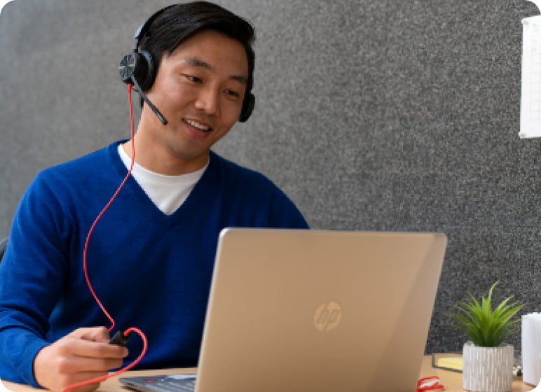 Un homme portant un casque et travaillant sur un ordinateur portable.