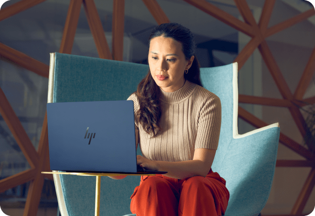 Professional analyzing data on a HP laptop in a workplace environment.
