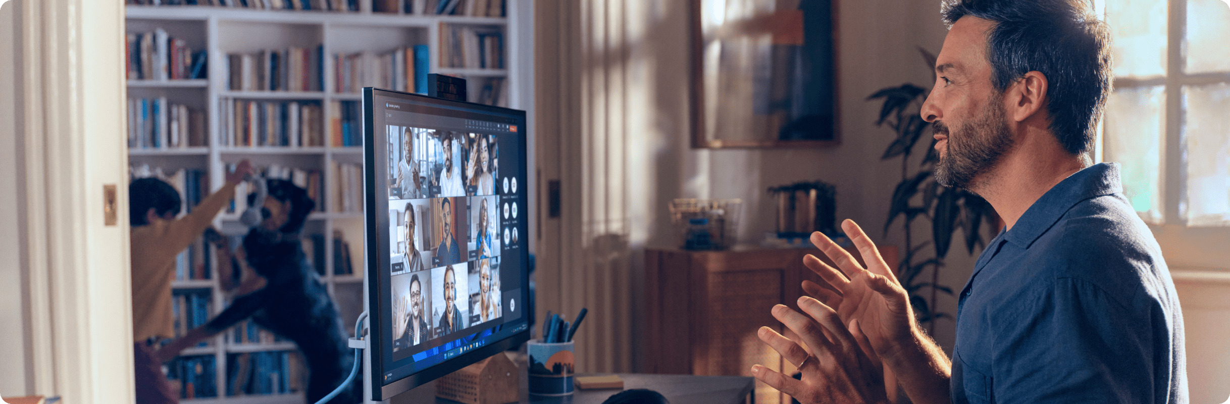 Professional participating in an HP desktop video call setup, gesturing with their hands while seated in a home office with bookshelves.