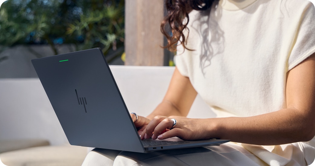 Professional typing on a laptop outdoors.