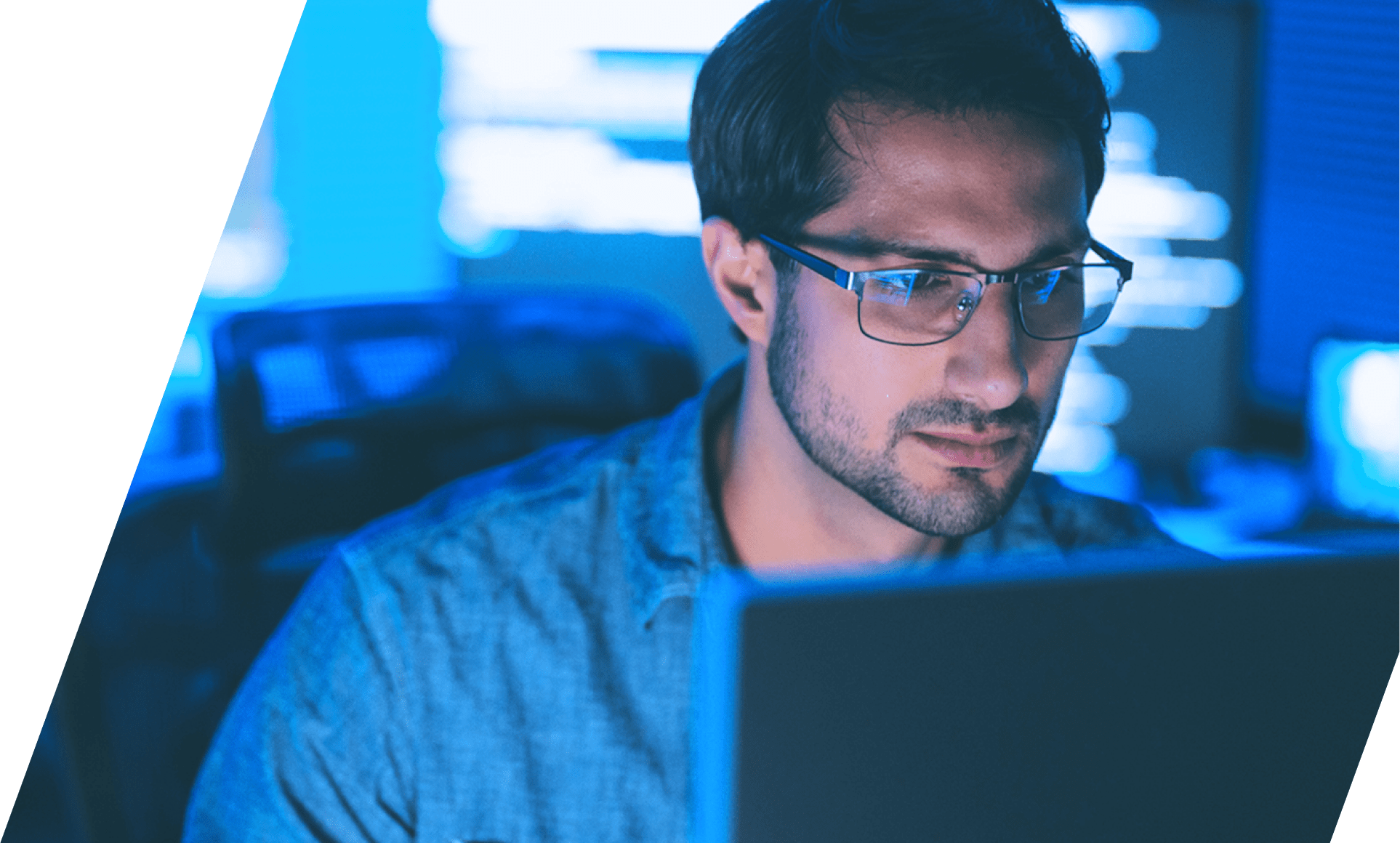 Close image of professional male in modern office with blue ambient lighting, working at HP laptop