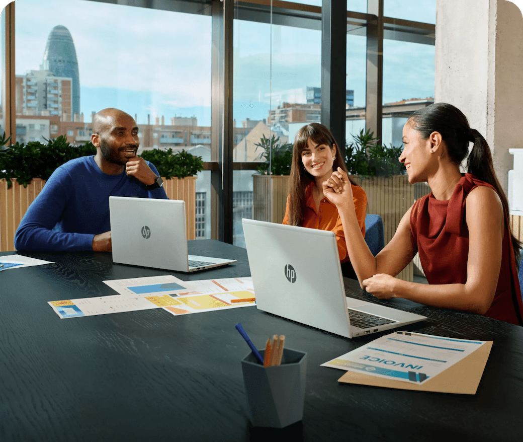 Team of professionals in modern office collaborating in shared workspace using HP laptops