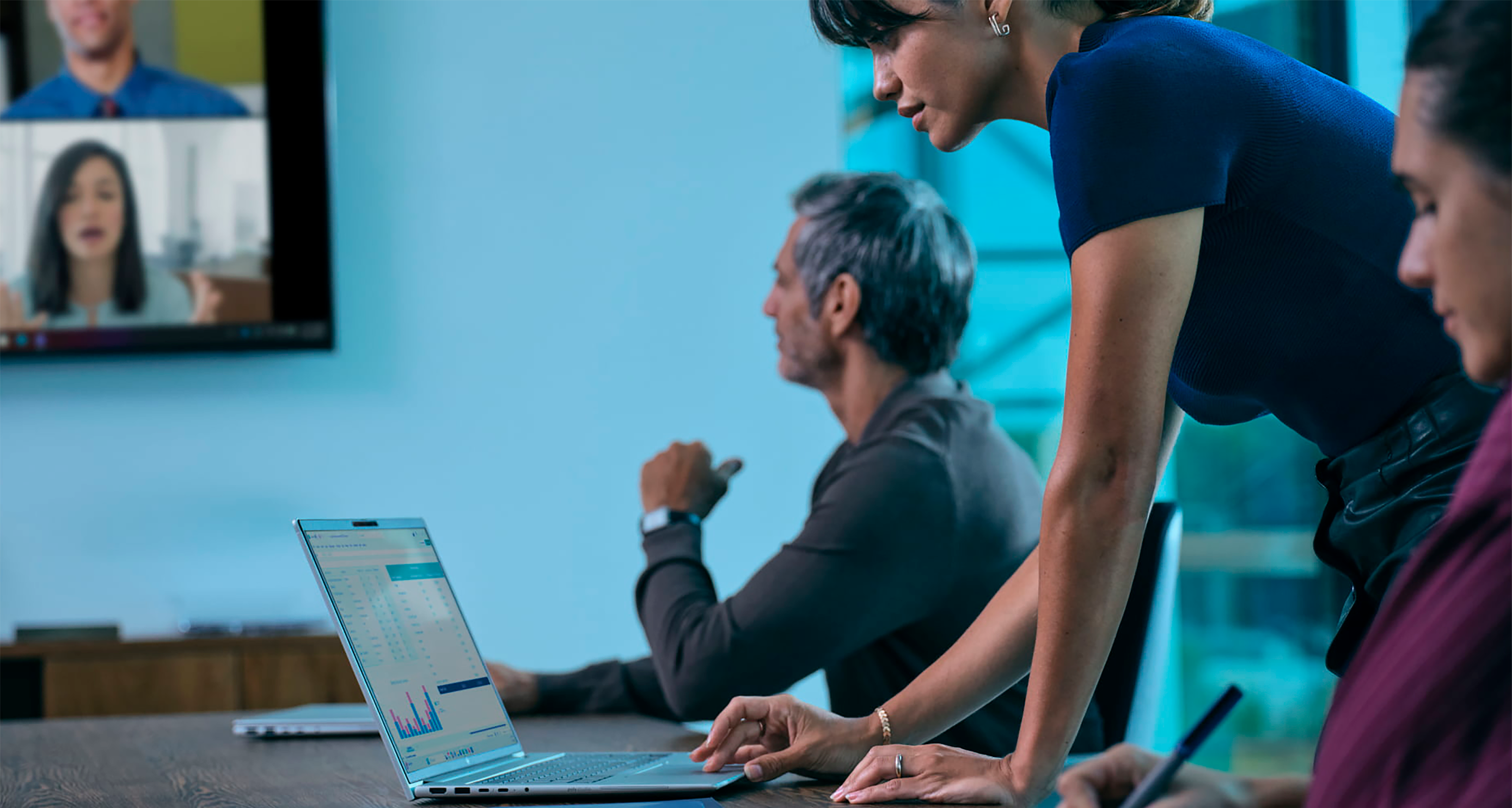 A woman working on an HP EliteBook laptop in a meeting with a coworker.