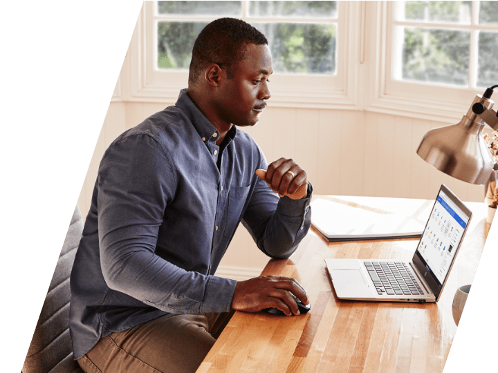 A man working on an HP laptop in his home office desk