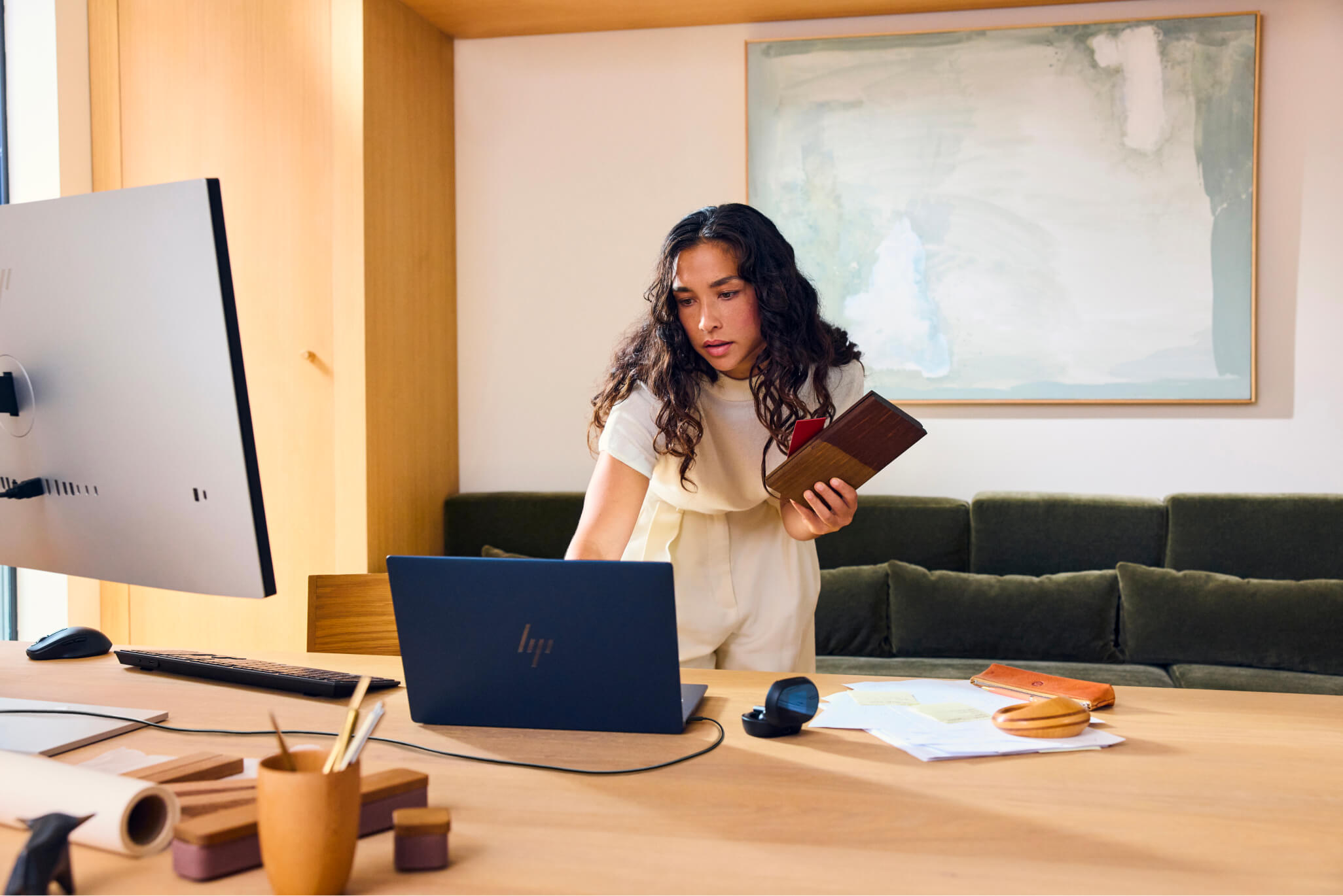 A businesswoman working on an HP laptop in a conference room.
