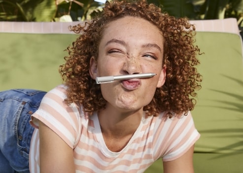 Woman holding a digital pen with her nose and mouth