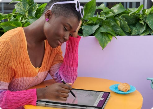 Woman drawing with a digital pen over a Pavilion x360 laptop in tablet mode