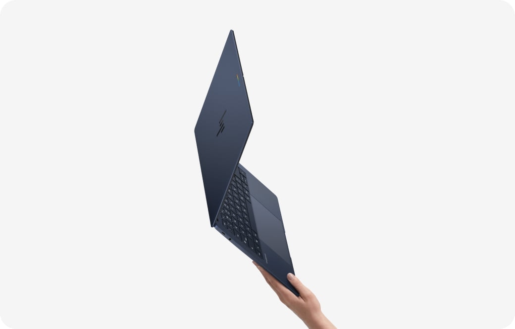 Ultra-thin HP laptop held in one hand with the display partially open, emphasizing the device’s lightweight design and portability.