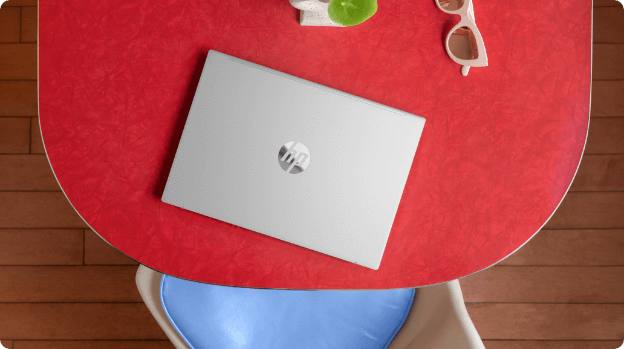 A closed HP Pavilion Aero 13.3 inch laptop over a red dining room table
