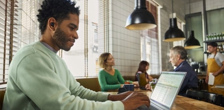Man wearing HP Poly earbuds that don't hurt
