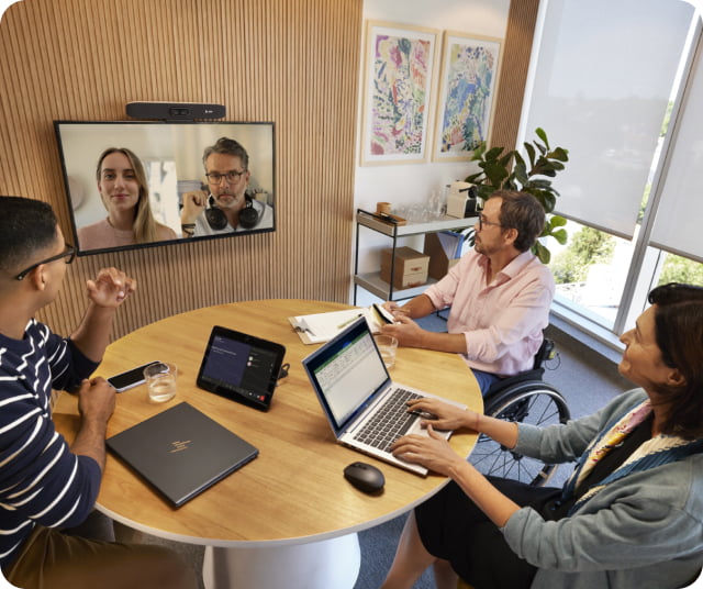 People working in a meeting room on a video conferencing call.