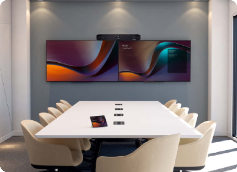 Empty meeting room with mounted dual screens and a video bar.