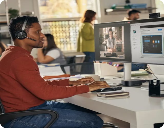 Man wearing an HP Poly headset and working on a computer.