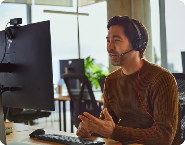 Man wearing and speaking through an HP Poly headset.