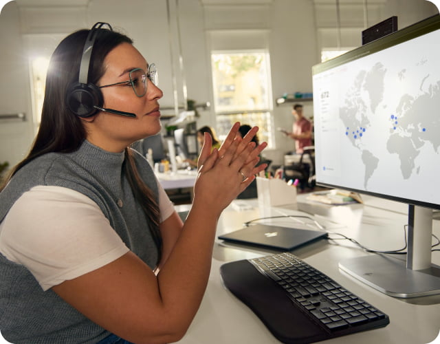 Woman wearing and speaking through an HP Poly headset.