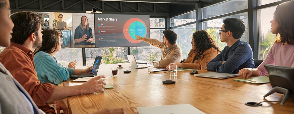 People on a video conferencing call in a large meeting room