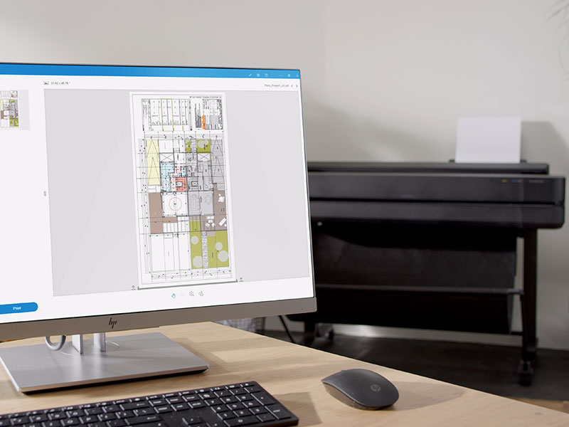 Monitor displaying technical drawing with HP DesignJet plotter in background