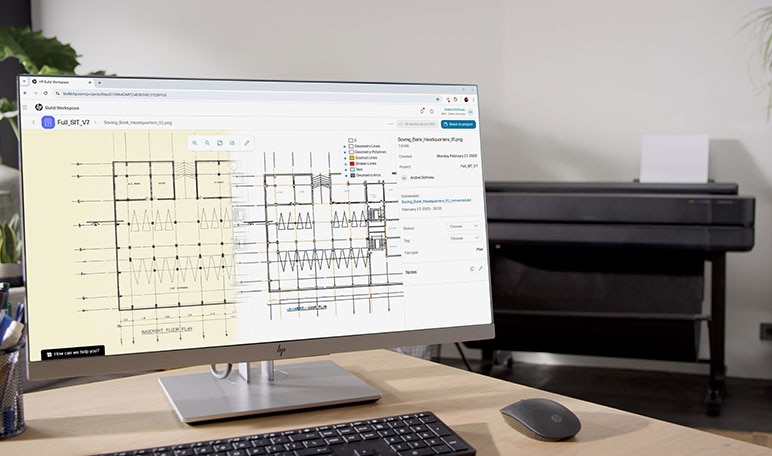 Monitor showing building plans with HP DesignJet printer in background