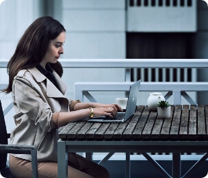 Eine Frau bei der Arbeit an ihrem HP Computer-Laptop auf einem Couchtisch
