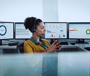 Eine IT-Mitarbeiterin betrachtet in ihrem Büro Daten auf HP Monitoren.
