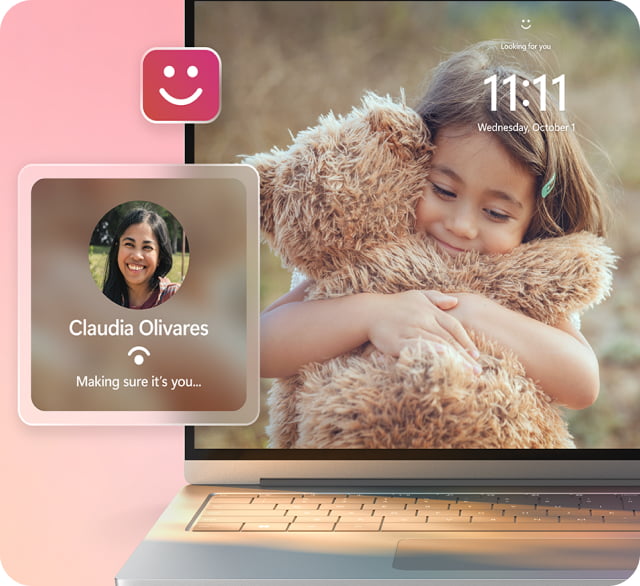笔记本电脑屏幕上正在显示锁屏画面，一个孩子抱着一只大泰迪熊，以及一个用于面部识别登录的弹出窗口，名称为“Claudia Olivares”。