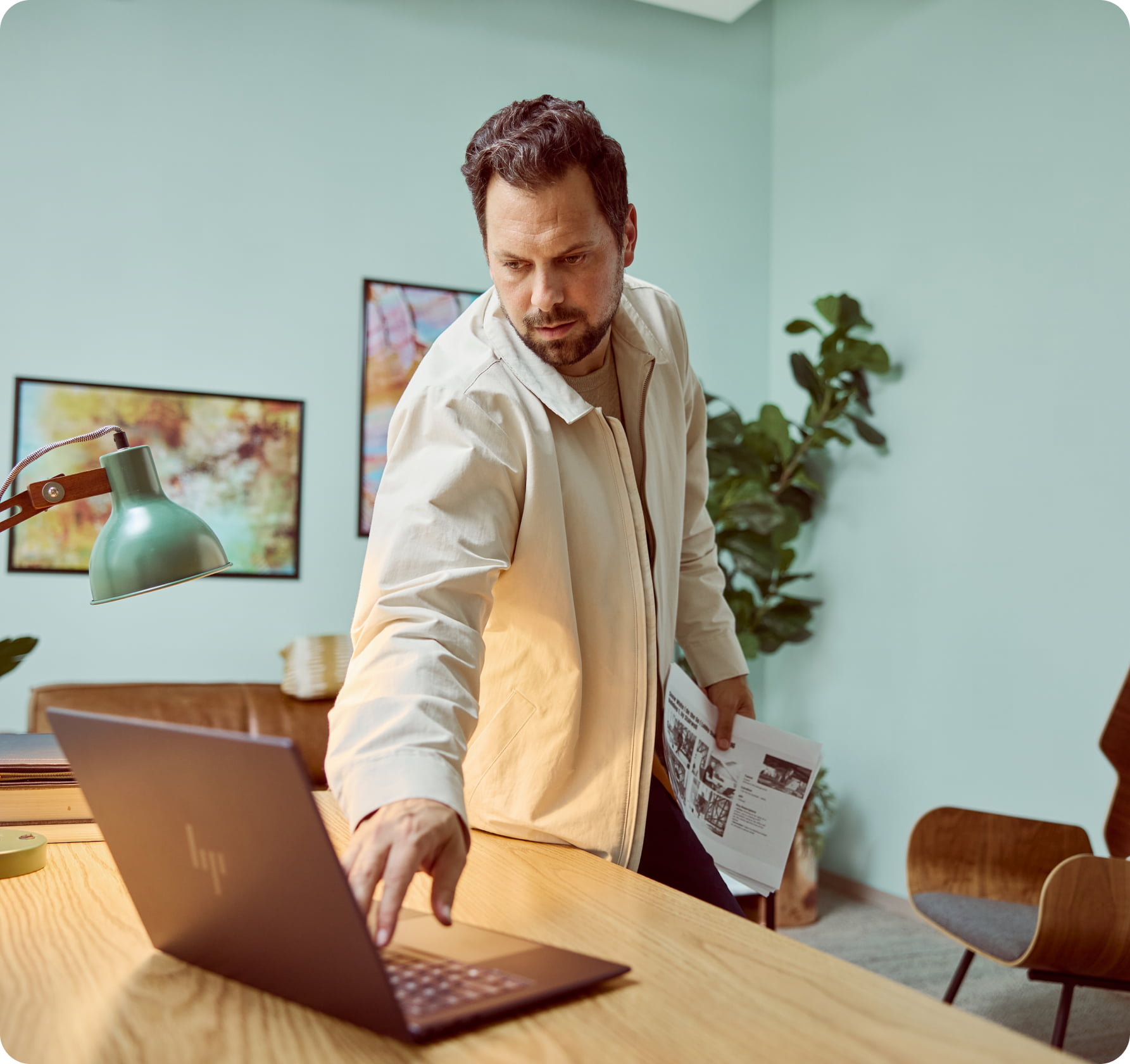 Man in modern, industrial office looking at a quad HP display, with HP keyboard and HP mouse, and a Poly headset