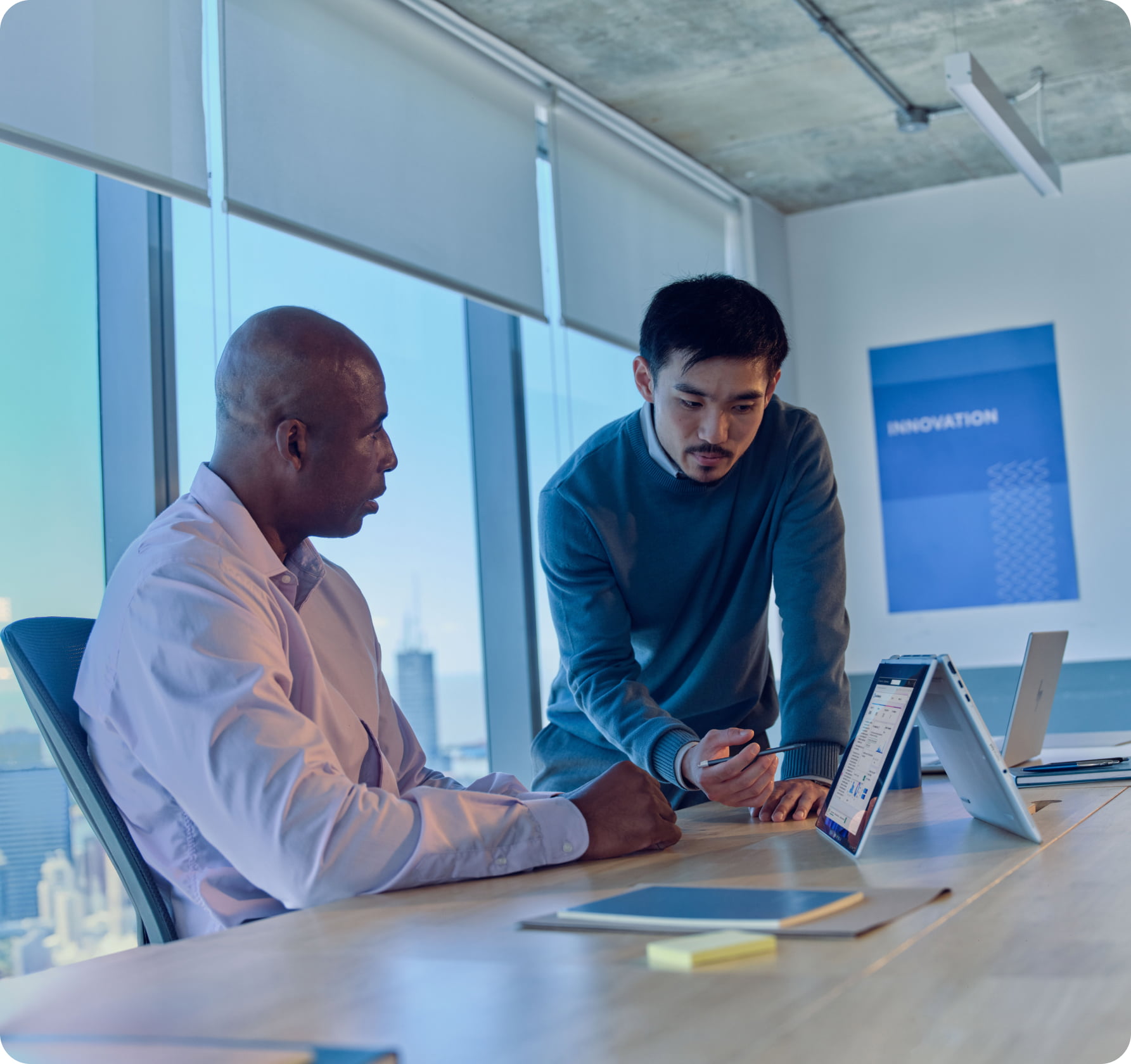 Man in modern, industrial office looking at a quad HP display, with HP keyboard and HP mouse, and a Poly headset