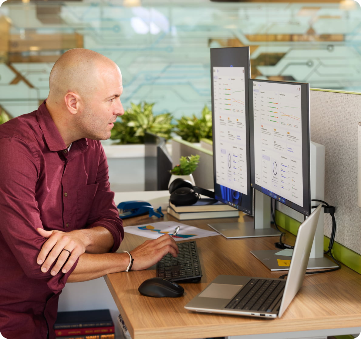 IT professional working on data with HP dual monitors and HP laptop