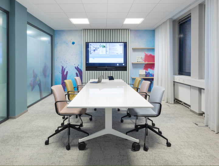 Modern conference room at Hannover Re office showing HP Poly collaboration screen and remote device controls