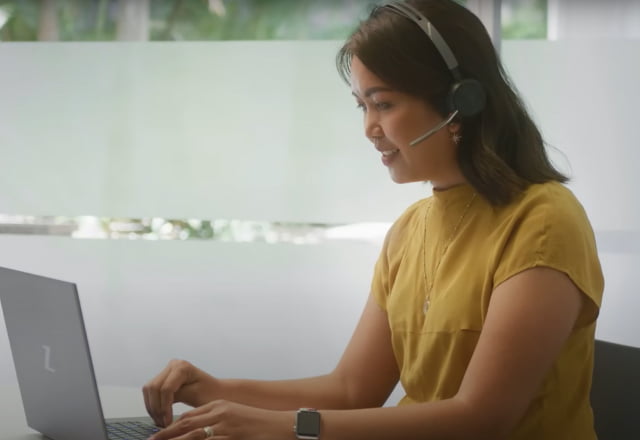female professional using HP Poly headset and HP laptop for a virtual meeting at her desk