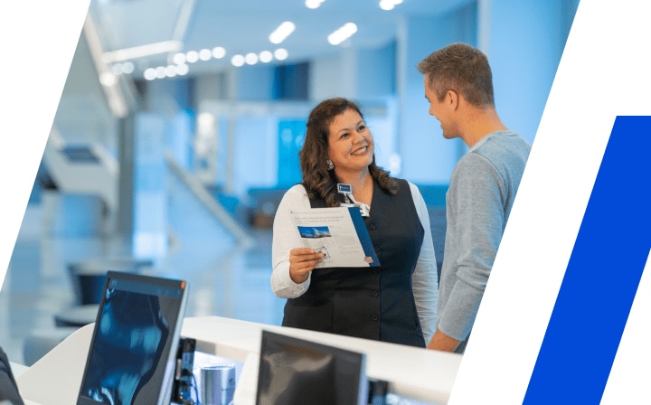 Female healthcare worker speaking with male patient while holding printed documents