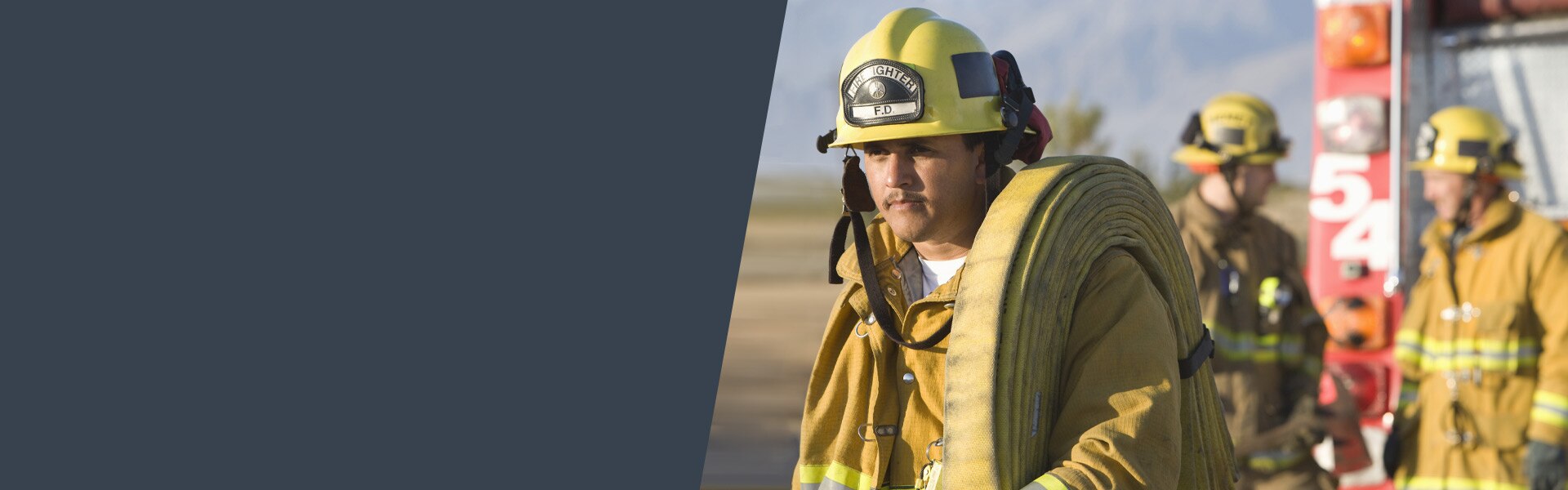 Image of firefighter carrying hose