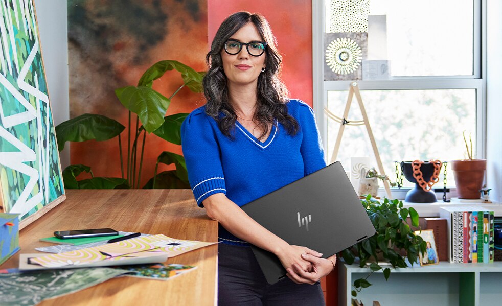 person standing with HP laptop in a studio