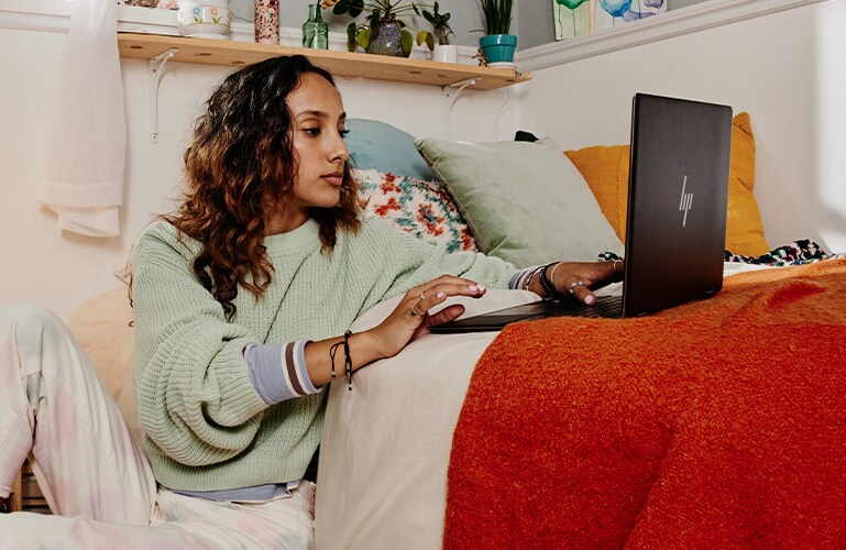 A person with a PC on a bed
