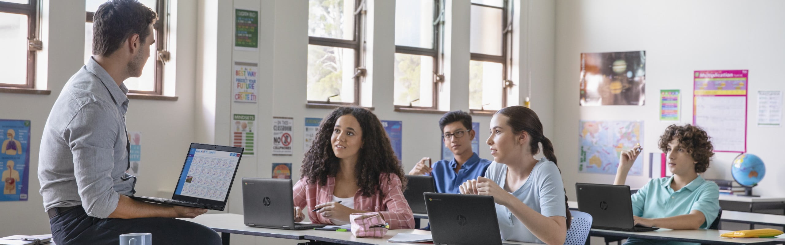 A teacher having a class using an HP laptop as well as his students.
