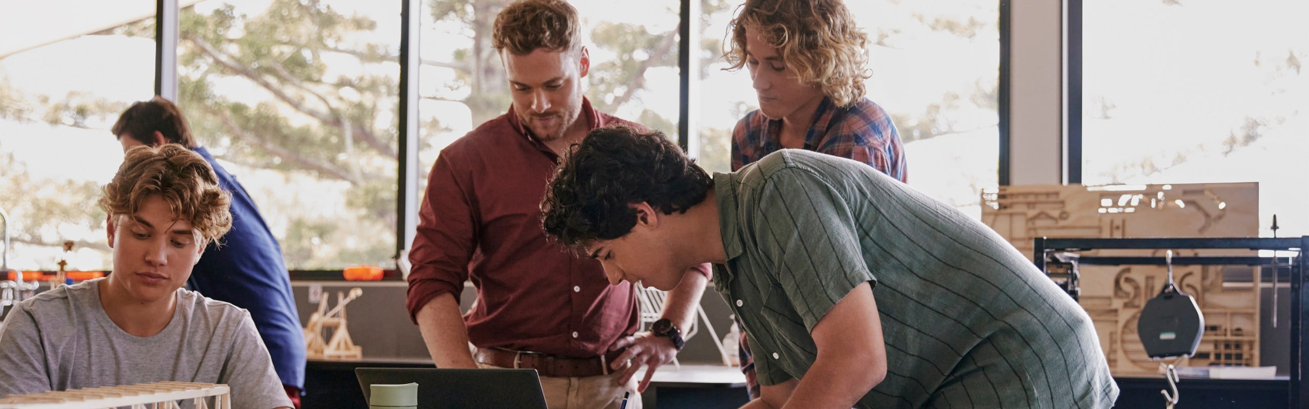 A group of students showing some information to their teacher with an HP laptop.