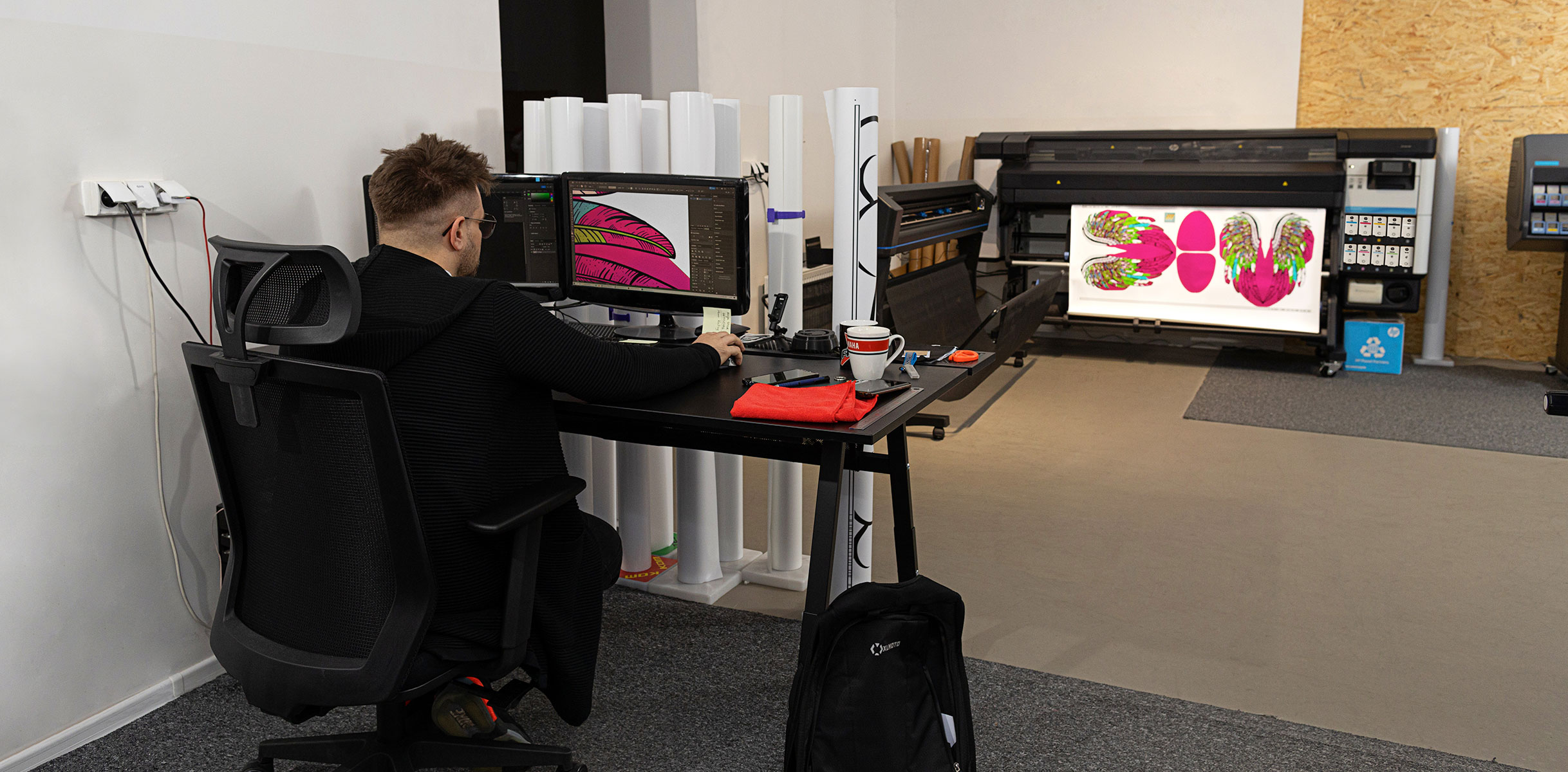 Persoon die achter een computer werkt voor HP Latex Print and Cut Plus-oplossingen