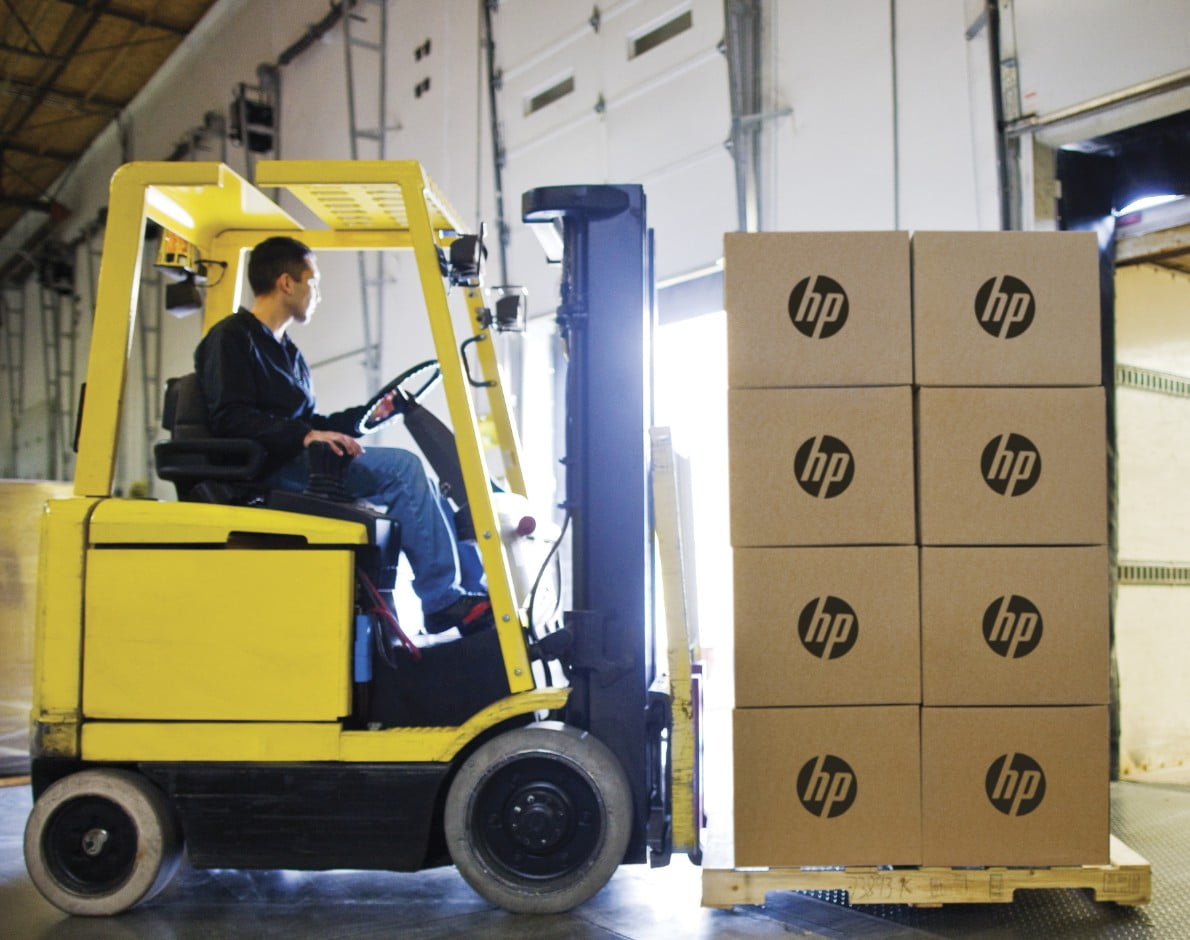 Worker using forklift to move HP products