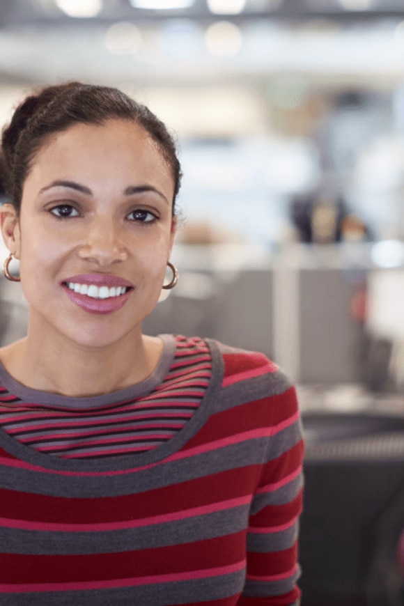 A woman smiling while standing in her office